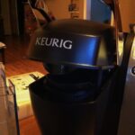 Close-up of the open K-Cup brewing chamber and chrome handle on a Keurig Model K70-5.
