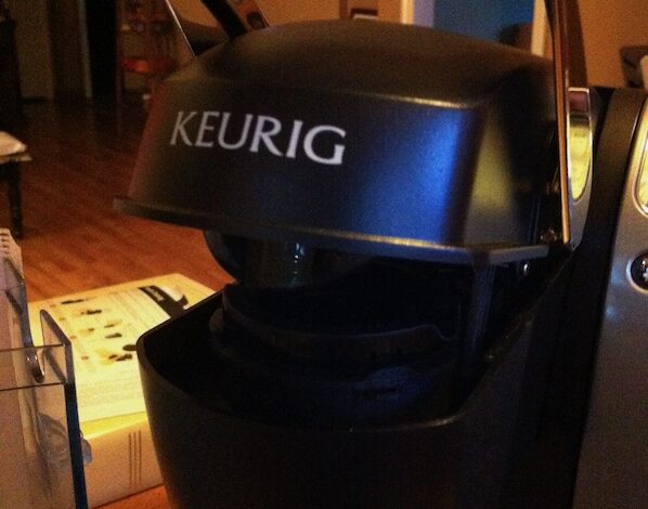 Close-up of the open K-Cup brewing chamber and chrome handle on a Keurig Model K70-5.