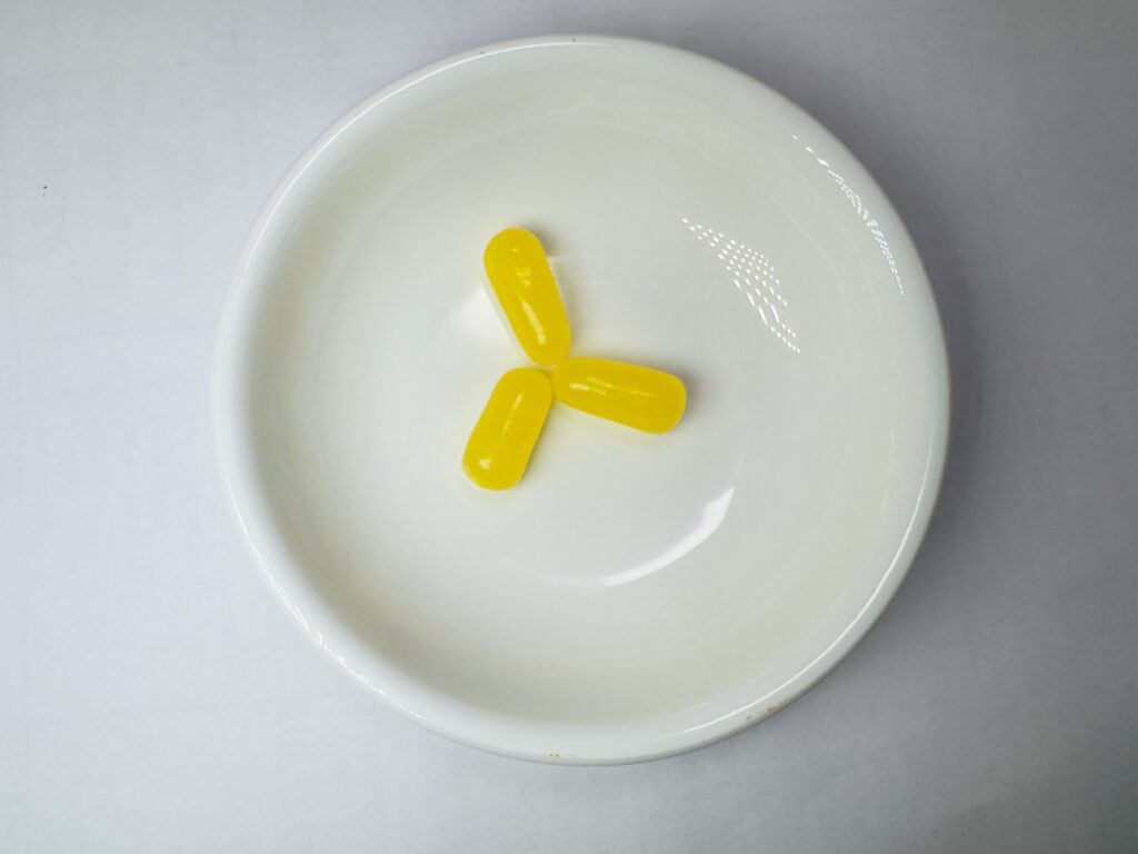 Three yellow Lemon flavored Mike and Ike candies arranged in a small white bowl.