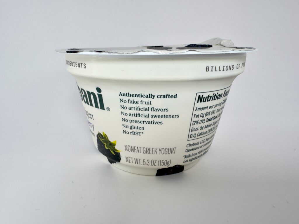 Side view of a Chobani Blackberry Greek Yogurt cup showing product claims: No fake fruit, no artificial flavors, and no artificial sweeteners.
