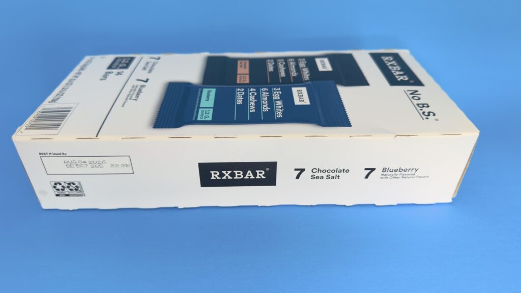 A side-angle view of the RXBAR 14-count variety pack box from Costco, showing the flavor counts and the "Best If Used By" date.