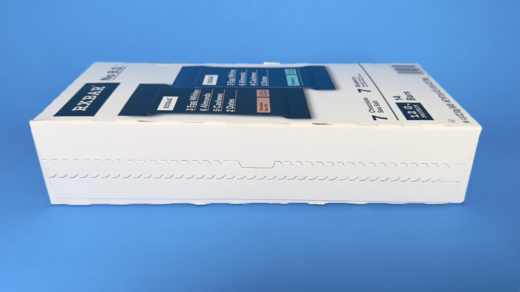 A side-angle view of the RXBAR 14-count variety pack box from Costco, showing the perferated die-cut packaging of the box.