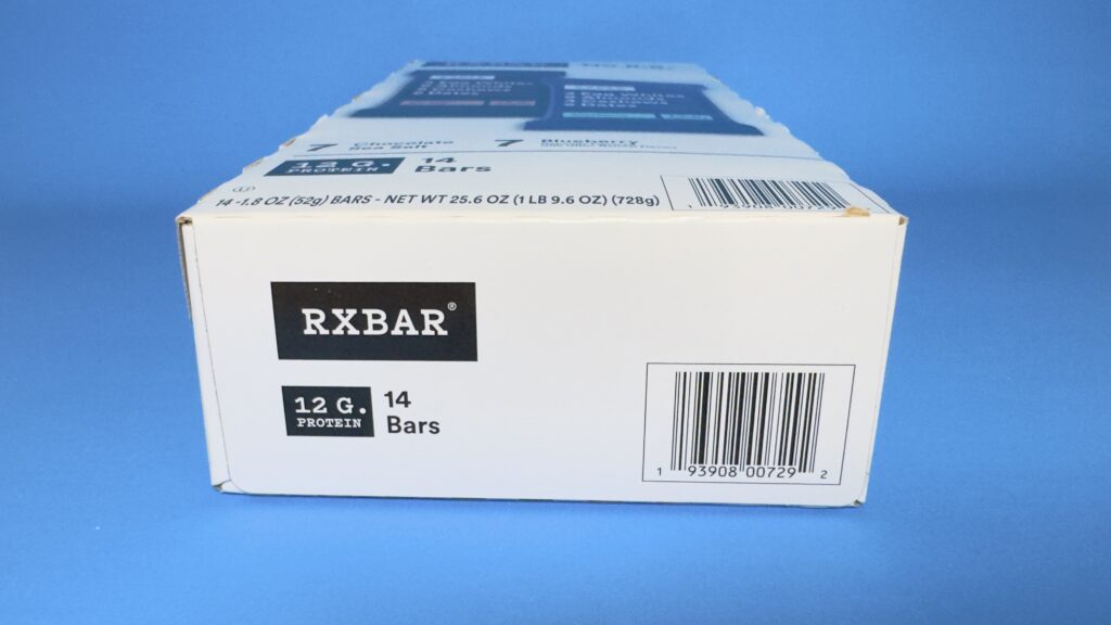 A close-up of the bottom panel of an RXBAR variety pack box from Costco, showing the 12g protein label, 14-count quantity, and the product UPC barcode.